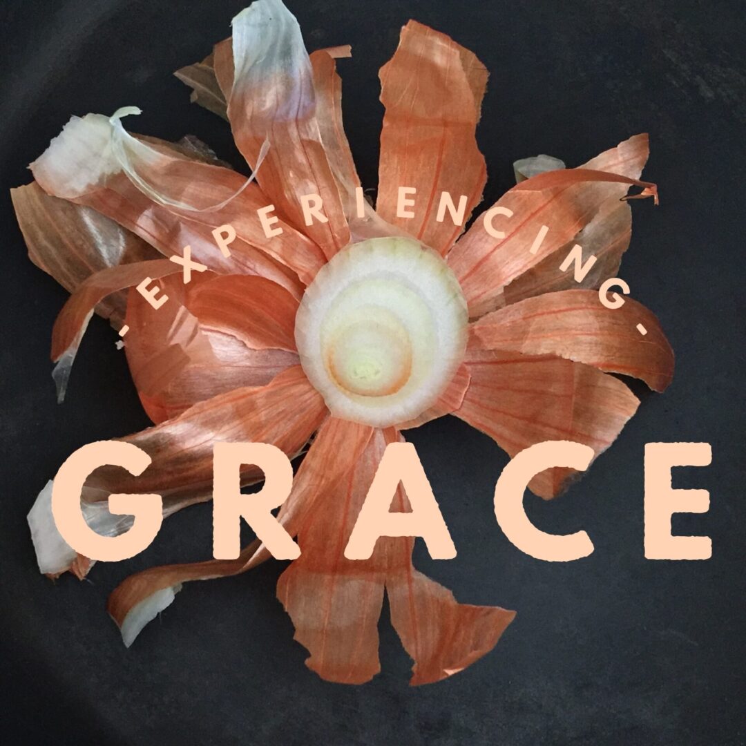 a poster saying EXPERIENCING GRACE with a pealed onion in the background