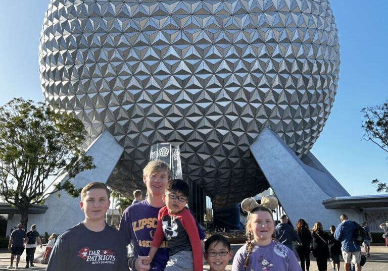A group of people standing in front of an attraction.